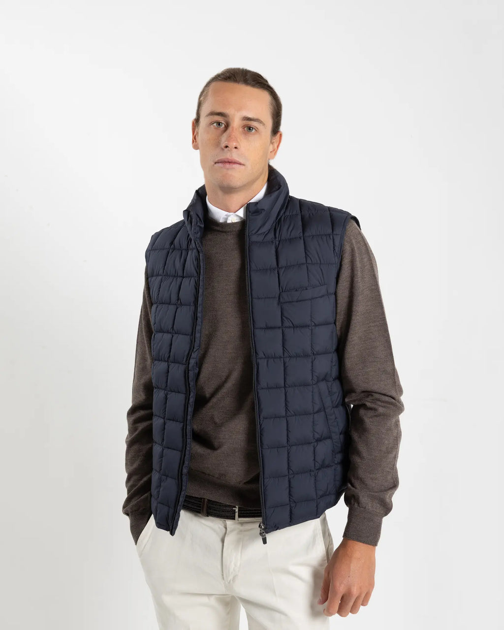 A clean, no-nonsense gilet built for layering. The box-quilt construction gives it structure and warmth, while the streamlined full-zip closure and high stand collar block the wind without adding bulk. Two side slip pockets sit flush with the quilting — functional without interrupting the clean lines.