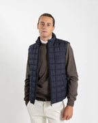 A clean, no-nonsense gilet built for layering. The box-quilt construction gives it structure and warmth, while the streamlined full-zip closure and high stand collar block the wind without adding bulk. Two side slip pockets sit flush with the quilting — functional without interrupting the clean lines.