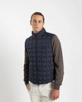 A clean, no-nonsense gilet built for layering. The box-quilt construction gives it structure and warmth, while the streamlined full-zip closure and high stand collar block the wind without adding bulk. Two side slip pockets sit flush with the quilting — functional without interrupting the clean lines.