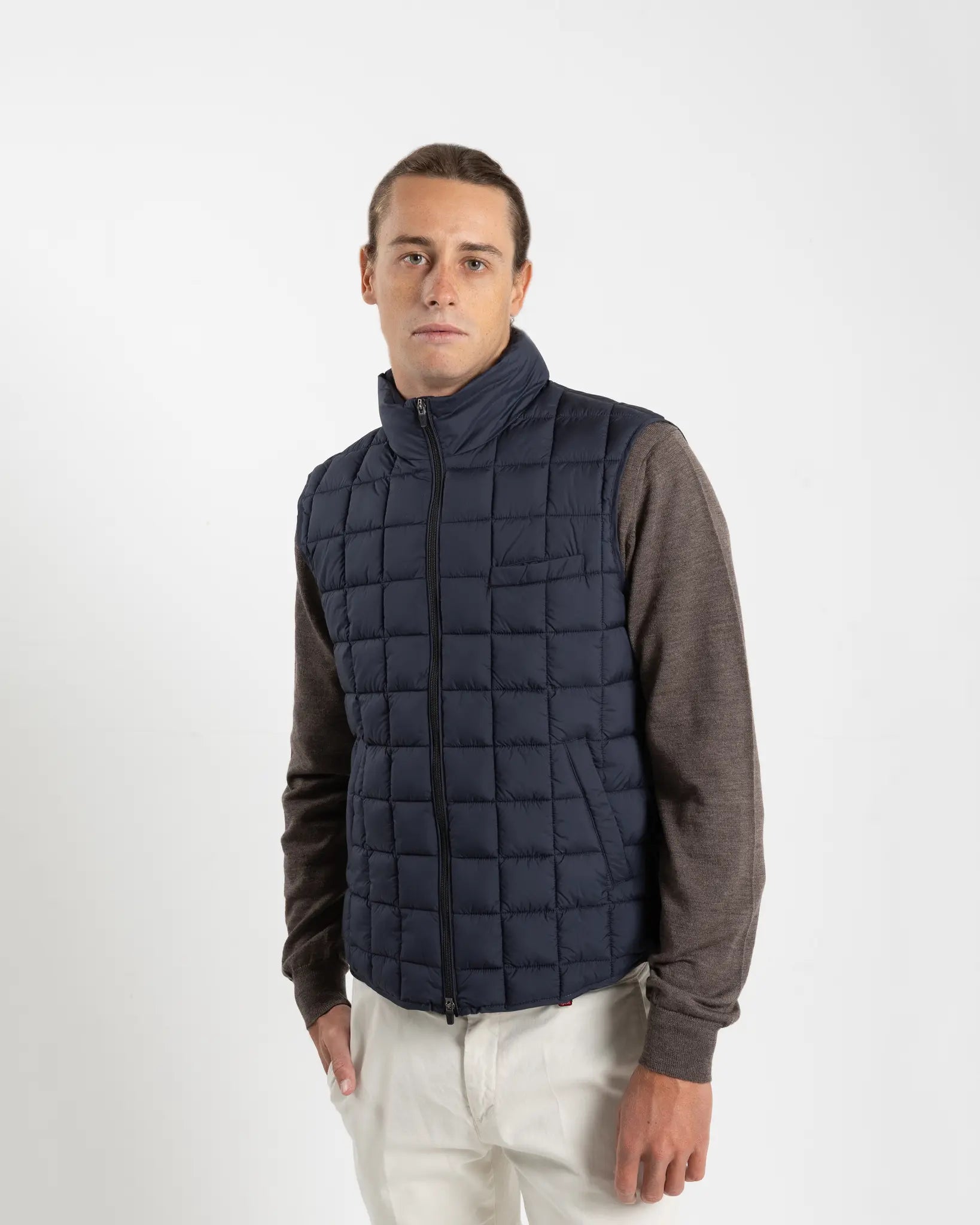 A clean, no-nonsense gilet built for layering. The box-quilt construction gives it structure and warmth, while the streamlined full-zip closure and high stand collar block the wind without adding bulk. Two side slip pockets sit flush with the quilting — functional without interrupting the clean lines.