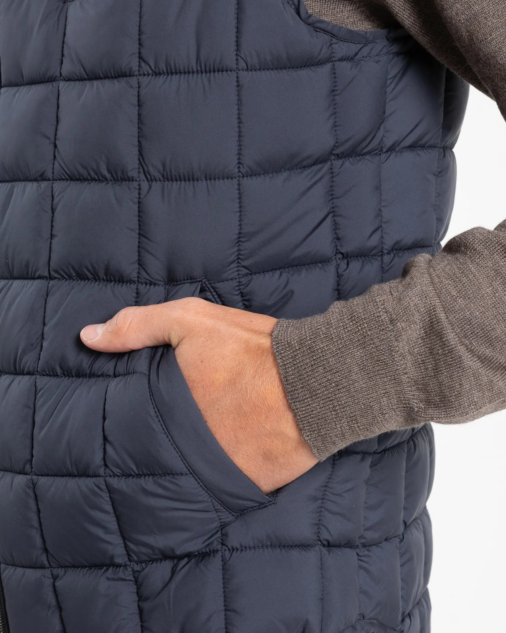 A clean, no-nonsense gilet built for layering. The box-quilt construction gives it structure and warmth, while the streamlined full-zip closure and high stand collar block the wind without adding bulk. Two side slip pockets sit flush with the quilting — functional without interrupting the clean lines.