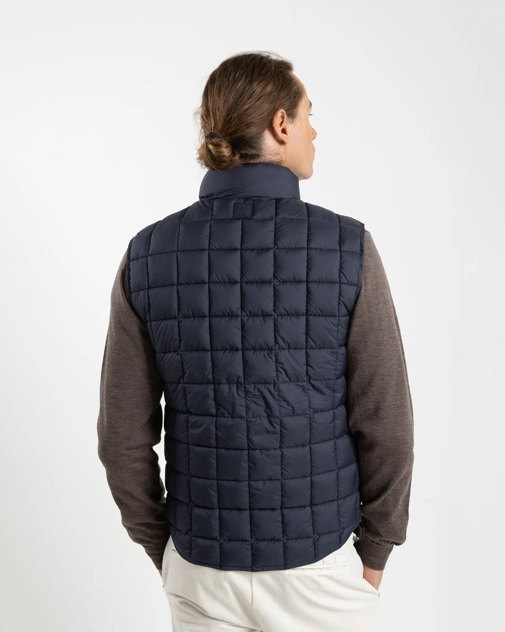 A clean, no-nonsense gilet built for layering. The box-quilt construction gives it structure and warmth, while the streamlined full-zip closure and high stand collar block the wind without adding bulk. Two side slip pockets sit flush with the quilting — functional without interrupting the clean lines.