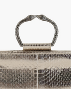 Clutch in precious silver-colored snake leather with round rigid body and removable leather strap.Brass bracelet, iconic accessory of the Tramontano archive handcrafted.Top closure with double magnets.

Microfiber lining. Accessories in gold finish.

Material: Snake Elaphe
Dimensions: 20x11x7 cm