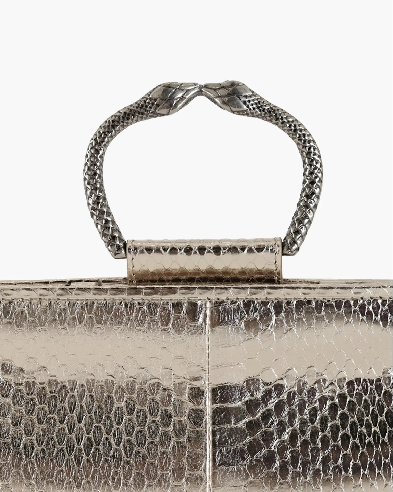 Clutch in precious silver-colored snake leather with round rigid body and removable leather strap.Brass bracelet, iconic accessory of the Tramontano archive handcrafted.Top closure with double magnets.

Microfiber lining. Accessories in gold finish.

Material: Snake Elaphe
Dimensions: 20x11x7 cm