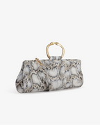 Clutch in precious snake leather with rounding rigid body and removable leather crossbody.Brass bracelet, iconic accessory of the Tramontano archive handcrafted.Top closure with double magnets. Microfiber lining. Accessories in gold finish. Material: Snake ElapheDimensions: 31x12x8 cm