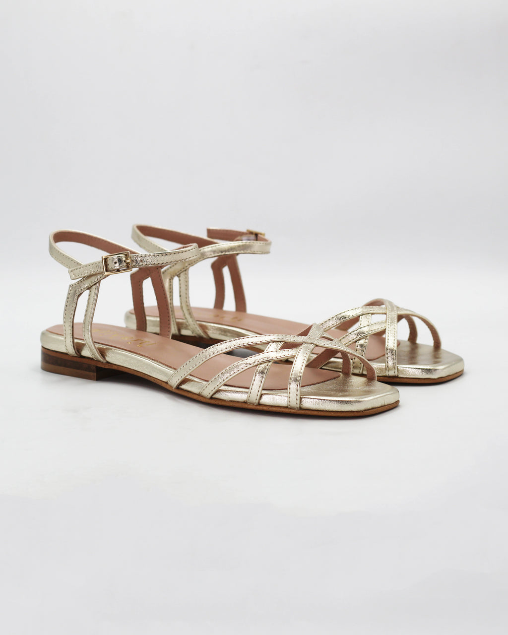 Shop the PATTY14 flat woven sandal in gold calf leather. Italian-made with a woven strap detail, adjustable ankle strap, and rubber sole. Effortless metallic elegance.