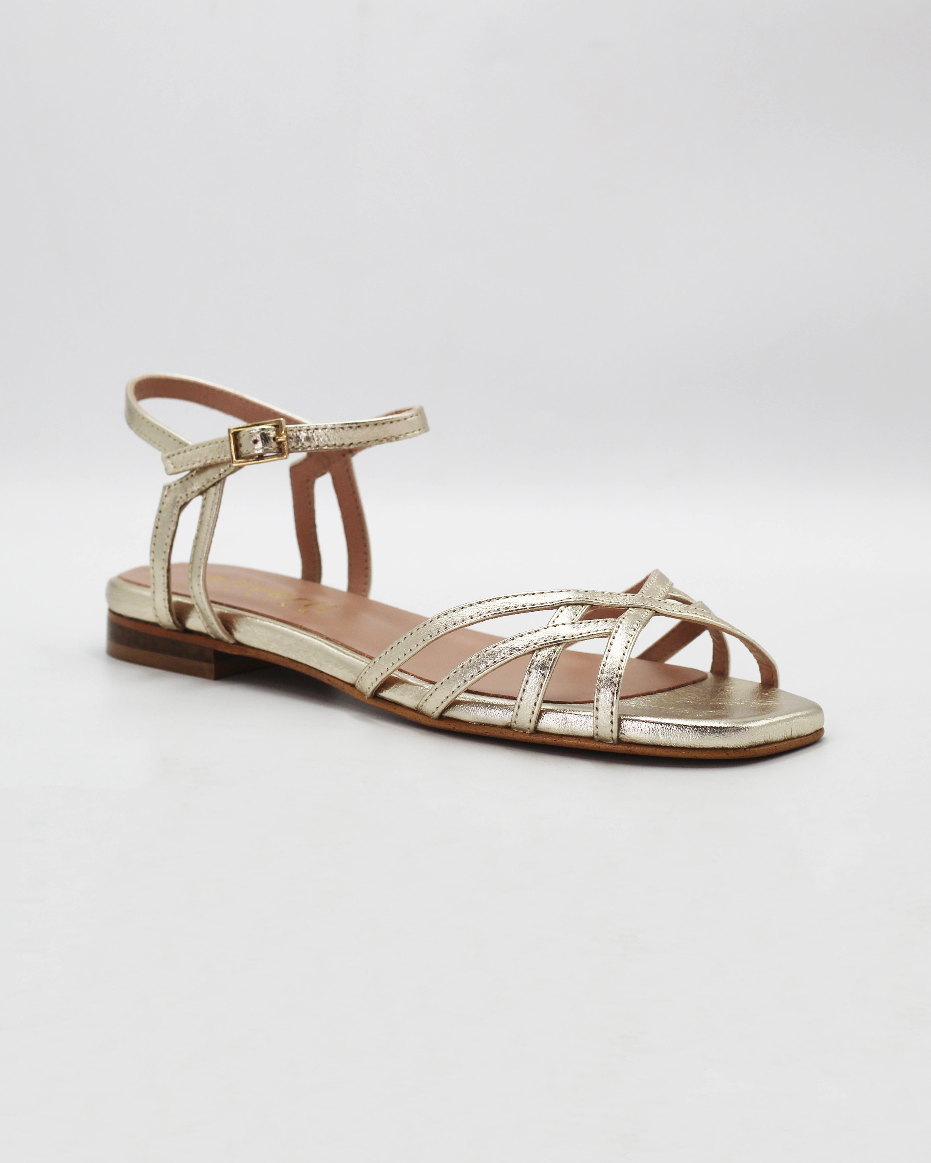 Shop the PATTY14 flat woven sandal in gold calf leather. Italian-made with a woven strap detail, adjustable ankle strap, and rubber sole. Effortless metallic elegance.
