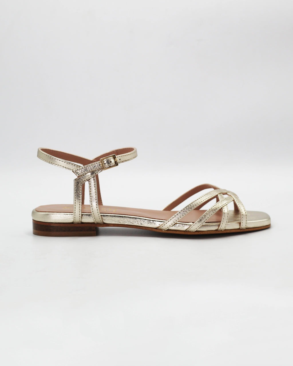 Shop the PATTY14 flat woven sandal in gold calf leather. Italian-made with a woven strap detail, adjustable ankle strap, and rubber sole. Effortless metallic elegance.