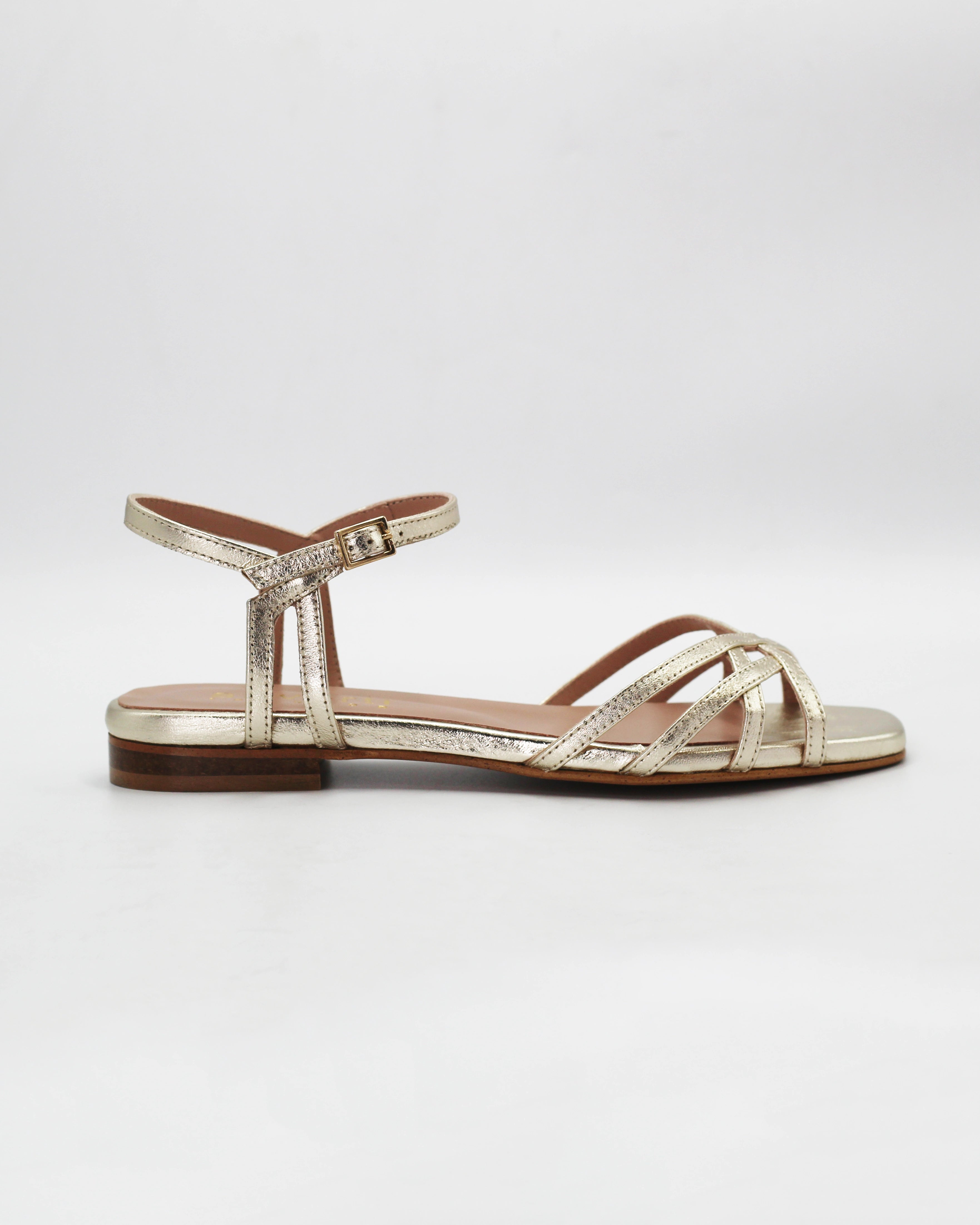 Shop the PATTY14 flat woven sandal in gold calf leather. Italian-made with a woven strap detail, adjustable ankle strap, and rubber sole. Effortless metallic elegance.