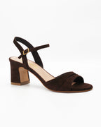Shop the RIVOLI23 block heel sandal in dark brown suede calf leather. Italian-made with a cut-out crossover strap, adjustable ankle strap, and rubber sole. Elevated summer elegance.