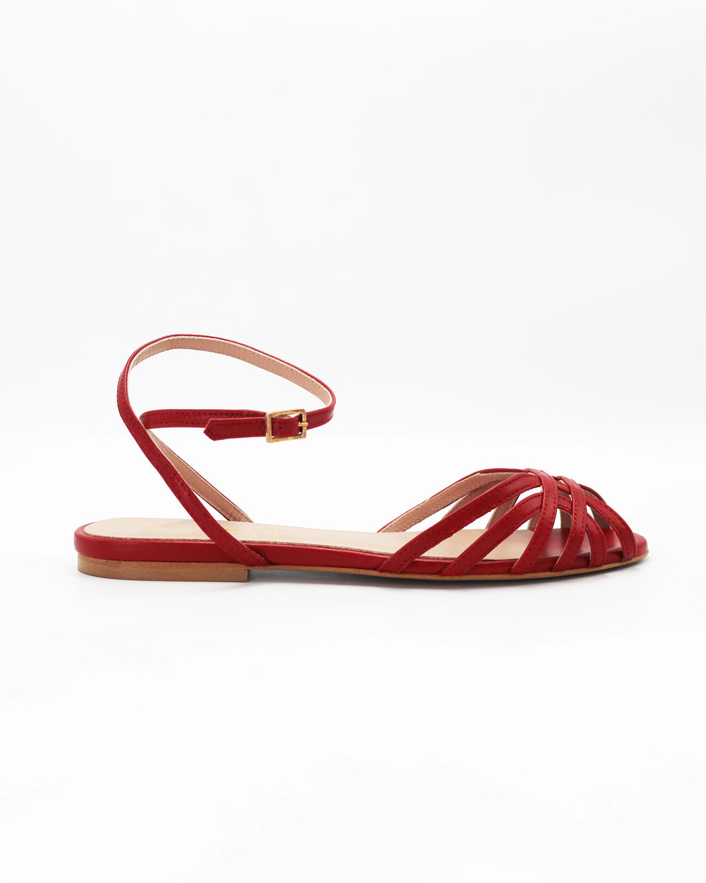Shop the CIRA5 flat lattice sandal in red calf leather. Italian-made with a woven strap detail, adjustable ankle strap, and rubber sole. Effortless summer elegance.