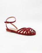 Shop the CIRA5 flat lattice sandal in red calf leather. Italian-made with a woven strap detail, adjustable ankle strap, and rubber sole. Effortless summer elegance.