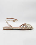 Shop the CIRA5 flat lattice sandal in gold calf leather. Italian-made with a woven strap detail, adjustable ankle strap, and rubber sole. Effortless metallic elegance.