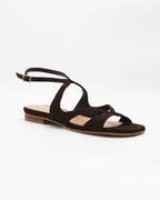 PATTY20 flat sandal in testa di moro suede with a sleek asymmetric toe strap and adjustable ankle strap. Handcrafted in Italy. Understated and easy.