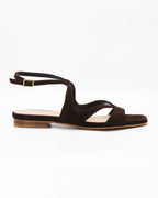 PATTY20 flat sandal in testa di moro suede with a sleek asymmetric toe strap and adjustable ankle strap. Handcrafted in Italy. Understated and easy.