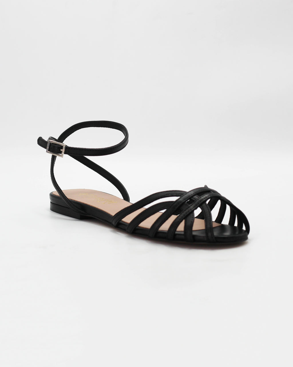 Shop the CIRA5 flat lattice sandal in black calf leather. Italian-made with a woven strap detail, adjustable ankle strap, and rubber sole. Classic summer elegance.