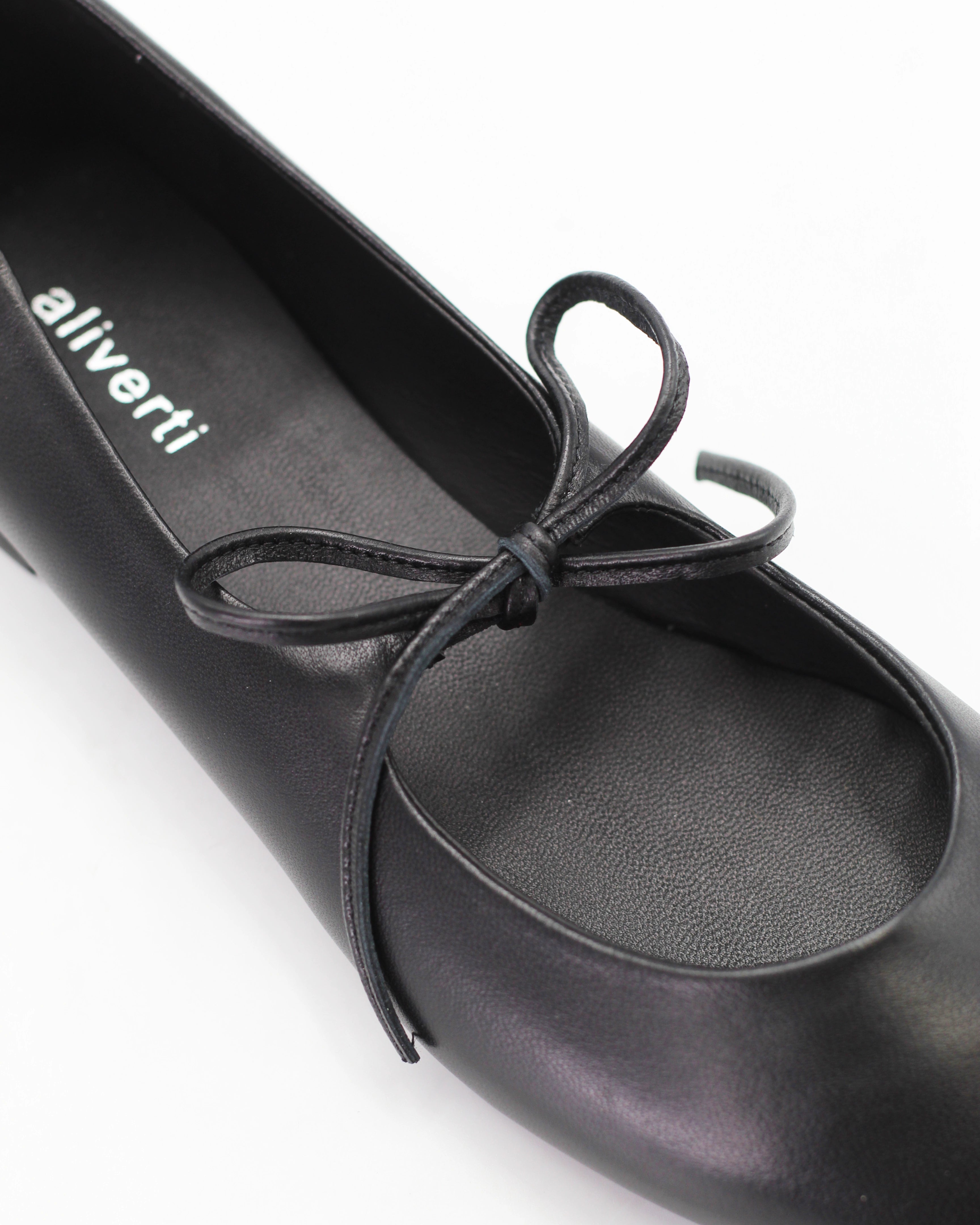 Elegant black ballerina pumps in Nero calf leather with a delicate lace-up bow. Handcrafted in Italy with a durable rubber sole. Timeless everyday luxury.