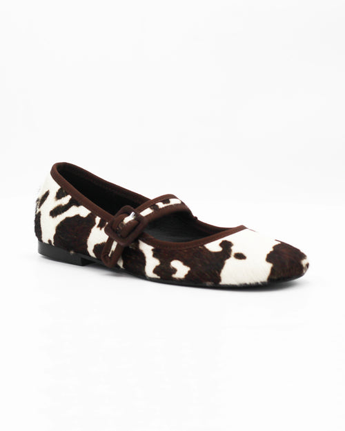Shop the 6050 Mary Jane ballerina flat in brown cow-print calf hair. Italian-made with a buckle strap and rubber sole. Playful everyday elegance.