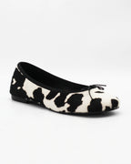 Shop the ESE6049 ballerina flat in black-and-white cow-print calf hair. Italian-made with a dainty bow detail and rubber sole. Playful everyday elegance.