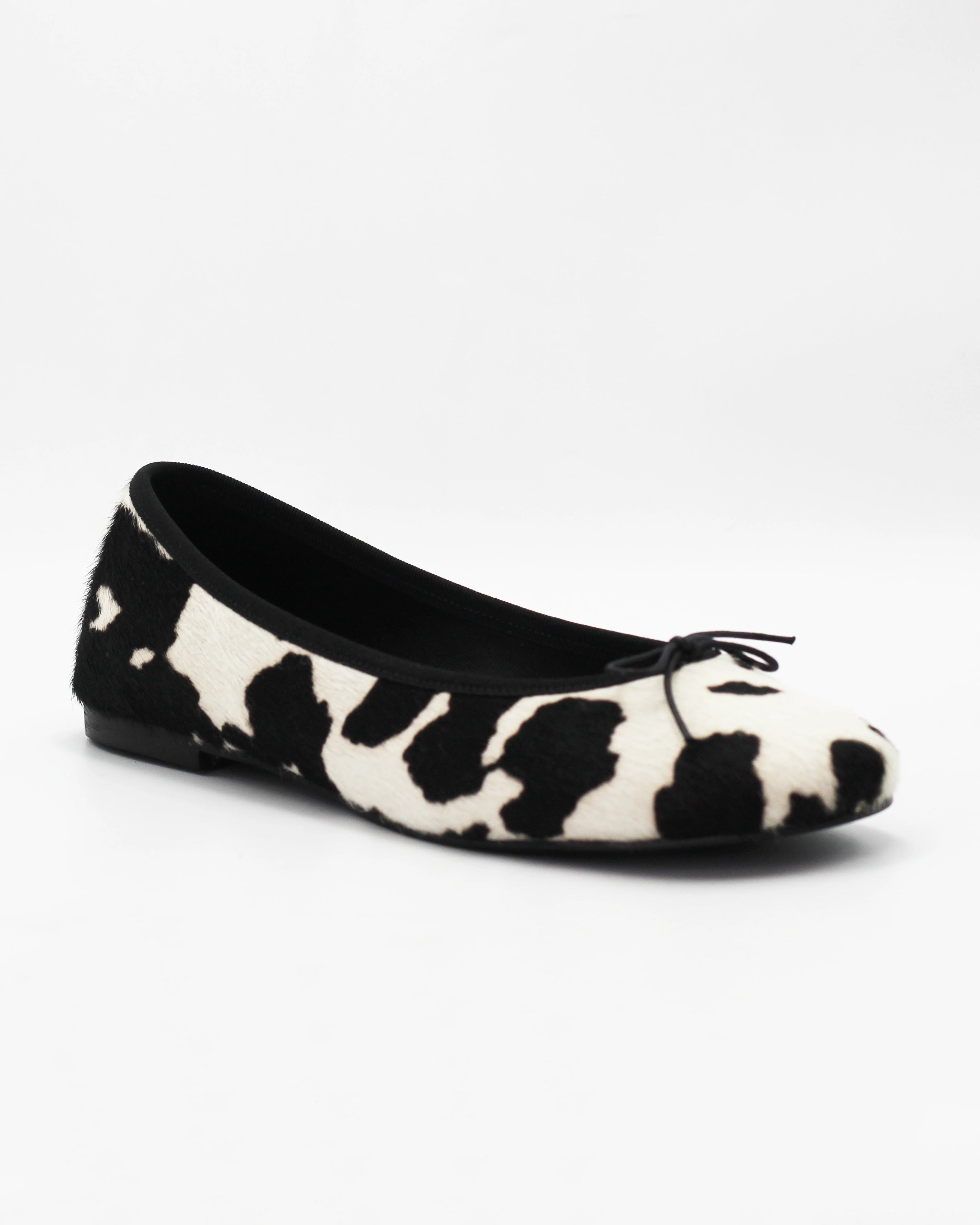 Shop the ESE6049 ballerina flat in black-and-white cow-print calf hair. Italian-made with a dainty bow detail and rubber sole. Playful everyday elegance.