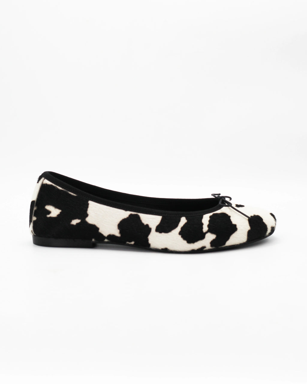 Shop the ESE6049 ballerina flat in black-and-white cow-print calf hair. Italian-made with a dainty bow detail and rubber sole. Playful everyday elegance.