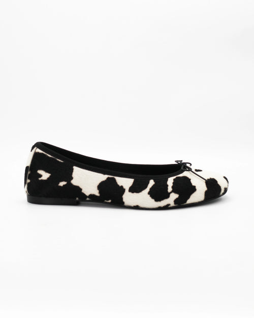 Shop the ESE6049 ballerina flat in black-and-white cow-print calf hair. Italian-made with a dainty bow detail and rubber sole. Playful everyday elegance.