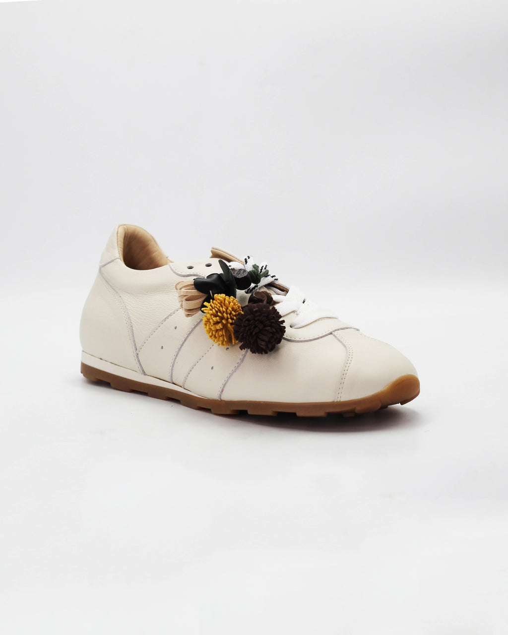 Shop the 6066 leather sneaker in cream calf leather. Italian-made with playful floral charm details and a rubber sole. Casual everyday elegance.