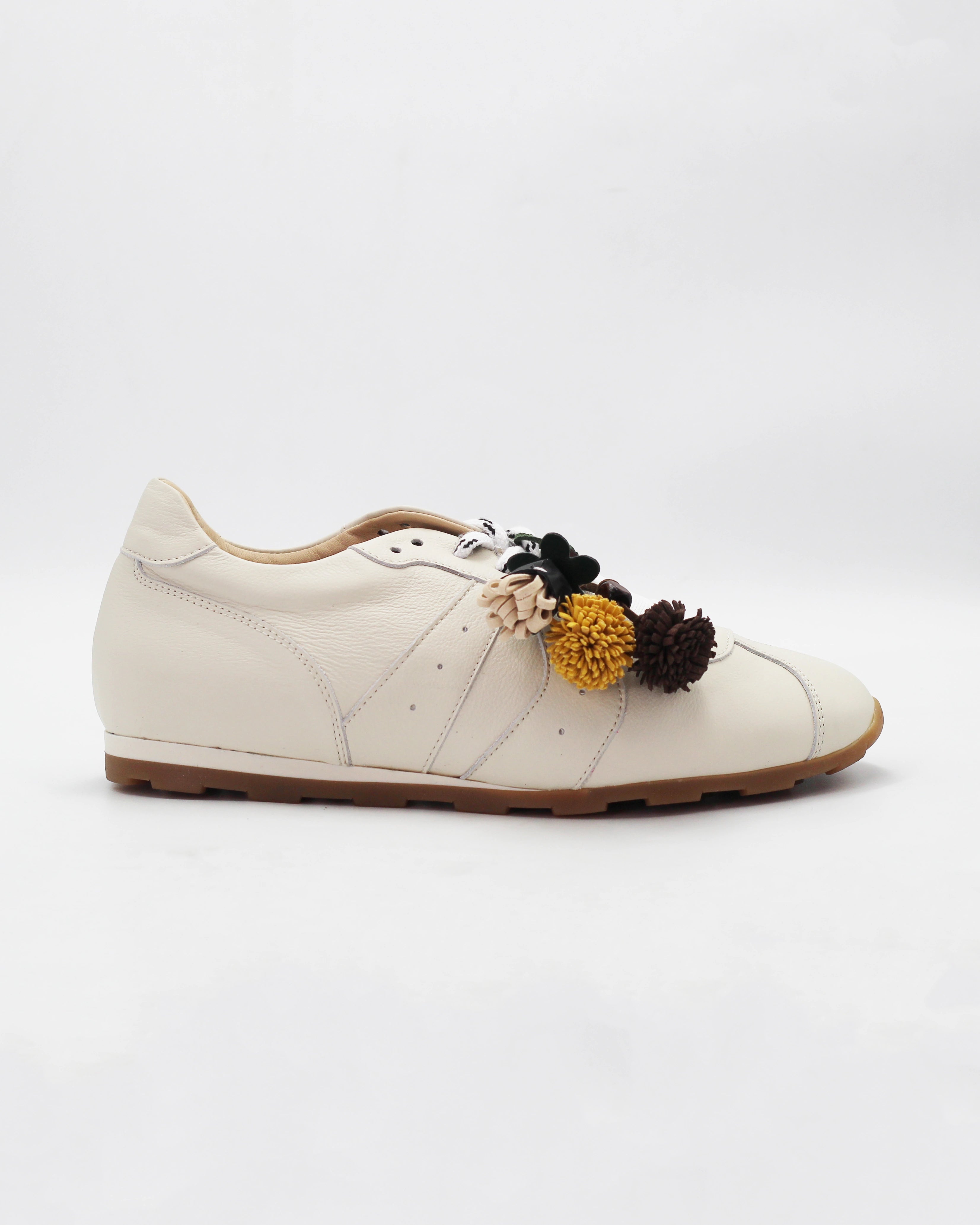 Shop the 6066 leather sneaker in cream calf leather. Italian-made with playful floral charm details and a rubber sole. Casual everyday elegance.