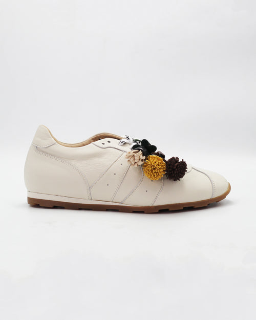 Shop the 6066 leather sneaker in cream calf leather. Italian-made with playful floral charm details and a rubber sole. Casual everyday elegance.