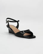 LYA3 low wedge sandal in nero calf leather with a smooth toe strap and adjustable ankle strap. Handcrafted in Italy. Effortless lift and comfort.