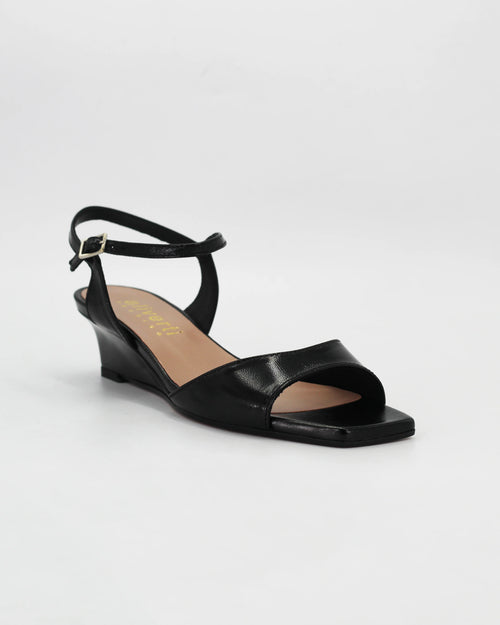 LYA3 low wedge sandal in nero calf leather with a smooth toe strap and adjustable ankle strap. Handcrafted in Italy. Effortless lift and comfort.