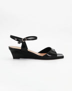 LYA3 low wedge sandal in nero calf leather with a smooth toe strap and adjustable ankle strap. Handcrafted in Italy. Effortless lift and comfort.