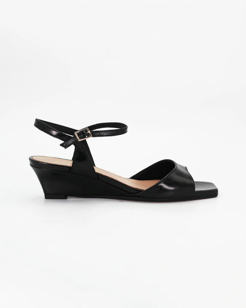 LYA3 low wedge sandal in nero calf leather with a smooth toe strap and adjustable ankle strap. Handcrafted in Italy. Effortless lift and comfort.