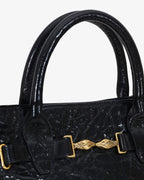 Mini bag made of precious lambskin with a crumpled effect and a delicate glossy finish, with double handles and a removable leather shoulder strap.
The bag is embellished on both the front and back with the iconic Tramontano archive accessory, in handcrafted gold-plated brass.
Top closure with magnet.

Microfiber lining.&nbsp;Gold-finish accessories.

Material:&nbsp;Moon lamb
Dimensions:&nbsp;25x13x10.5 cm