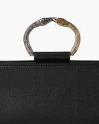 Laminated leather clutch with rounding rigid body and removable leather strail strap.Brass double-sided braceletDouble gold and silver color, iconic accessory of the Tramontano archive handcrafted. Top closure with double magnets. Microfiber lining. Accessories in silver finish. Material: shimmer calfDimensions: 31x12x8 cm