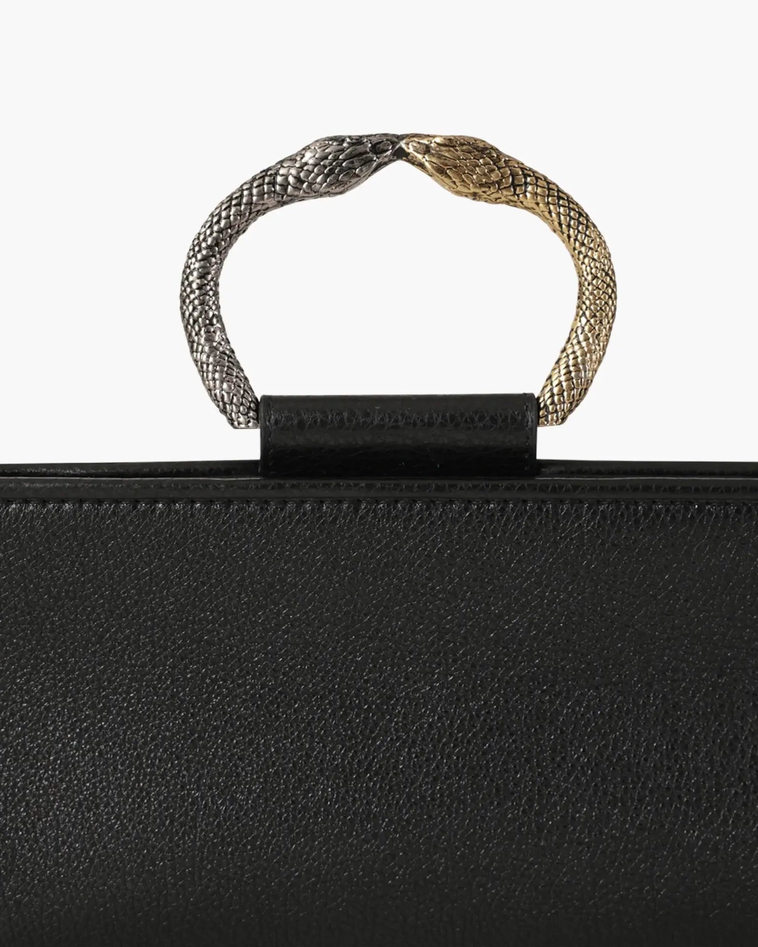 Laminated leather clutch with rounding rigid body and removable leather strail strap.Brass double-sided braceletDouble gold and silver color, iconic accessory of the Tramontano archive handcrafted. Top closure with double magnets. Microfiber lining. Accessories in silver finish. Material: shimmer calfDimensions: 31x12x8 cm