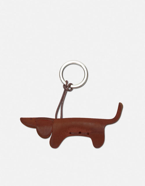 A quiet celebration of Italian artistry. Handcrafted from premium vegetable-tanned calfskin - free from toxic substances and entirely metal free - this dachshund keychain is the kind of detail that says everything without trying. The leather is naturally soft yet enduring, deepening in character with everyday wear. Finished with hand-stitched seams and a nickel key ring bearing a fire-printed logo.

Dimensions: 4 × 10 cm

Made in Italy.&nbsp;